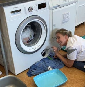 Dierenartsassistente repareert de wasmachine 